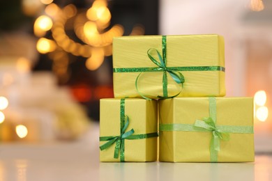 Beautifully wrapped gift boxes against blurred festive lights, space for text. Christmas celebration
