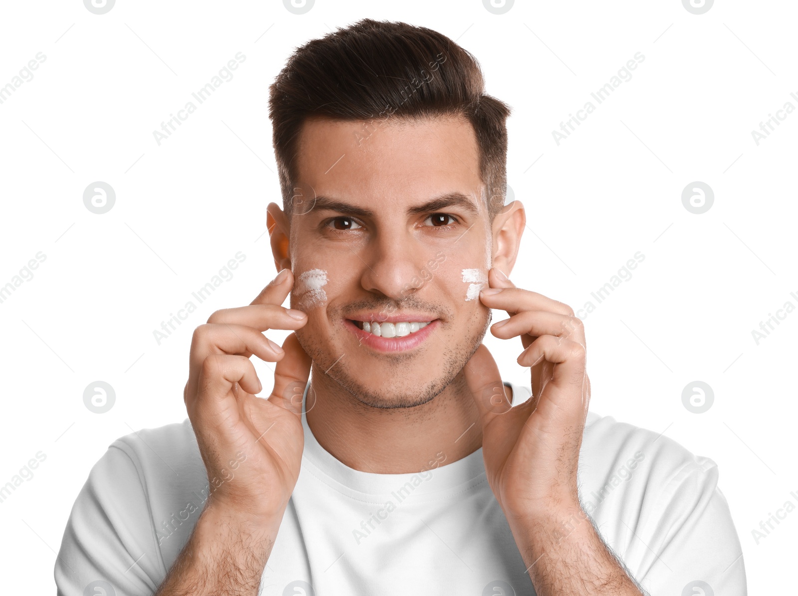 Photo of Handsome man applying face cream on white background