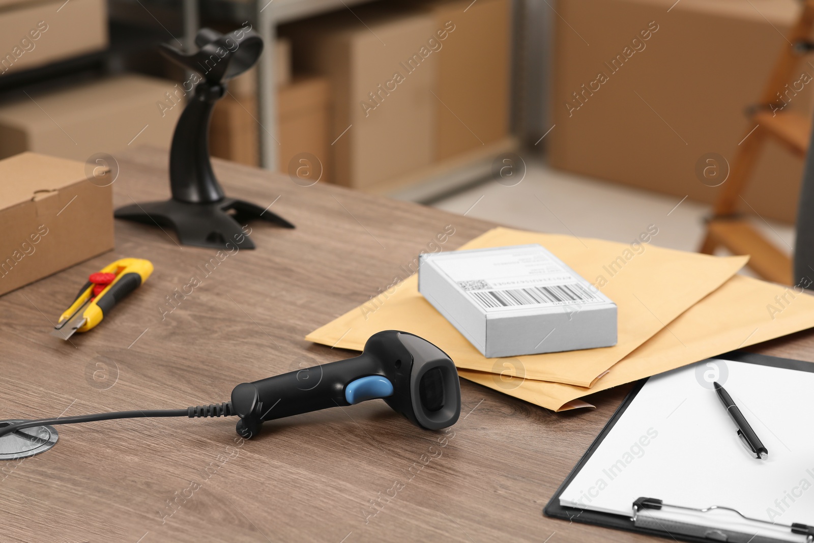 Photo of Black modern barcode scanner on wooden table in office. Online store