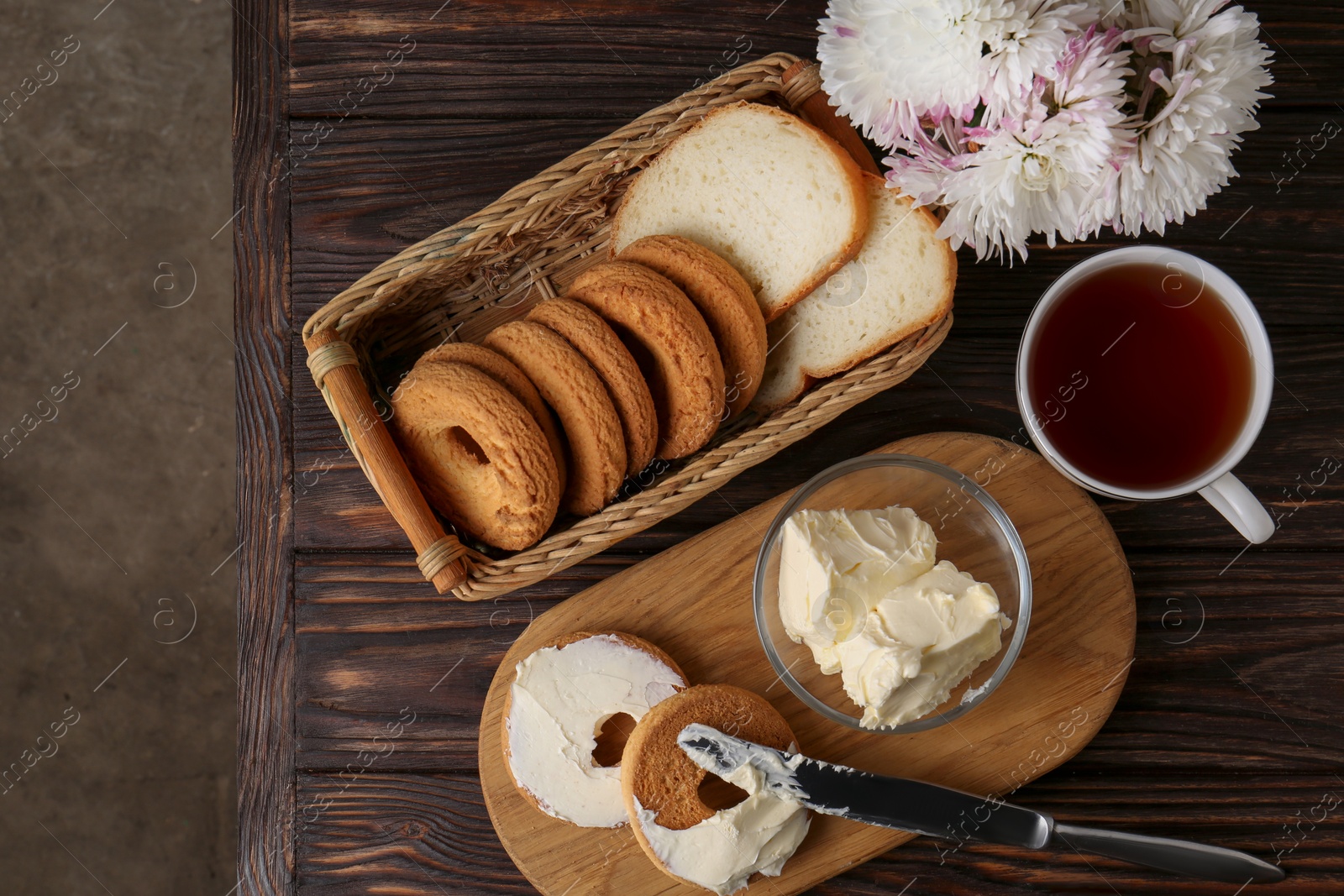 Photo of Tasty homemade butter, cookies and tea on wooden table, flat lay