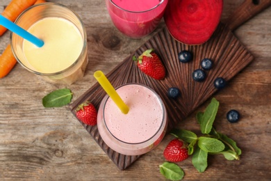 Photo of Flat lay composition with healthy detox smoothies and ingredients on wooden background