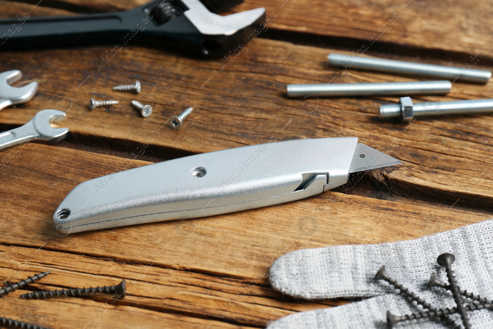 Photo of Utility knife and different tools on wooden table