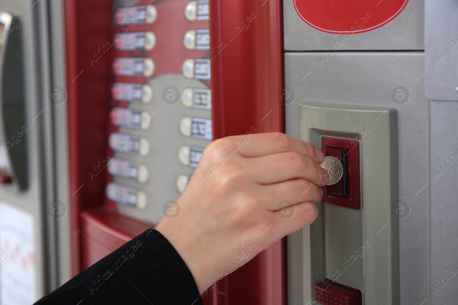 Image of Using coffee vending machine. Woman inserting coin to pay for drink, closeup