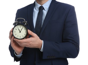 Businessman holding alarm clock on white background, closeup. Time management