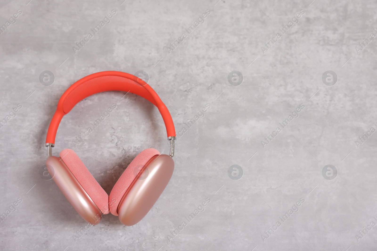 Photo of Stylish pink headphones on light grey table, top view. Space for text