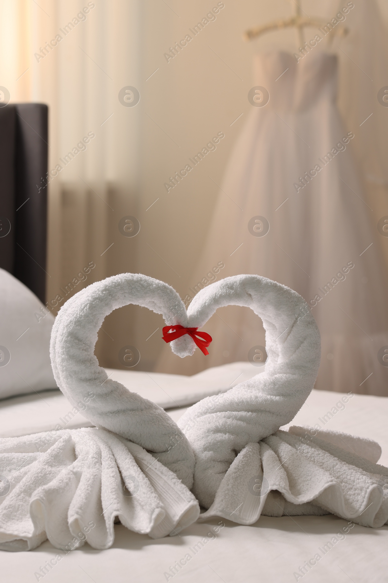 Photo of Honeymoon. Swans made of towels on bed in room