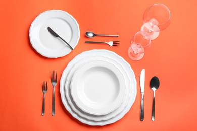 Photo of Elegant table setting on orange background, flat lay