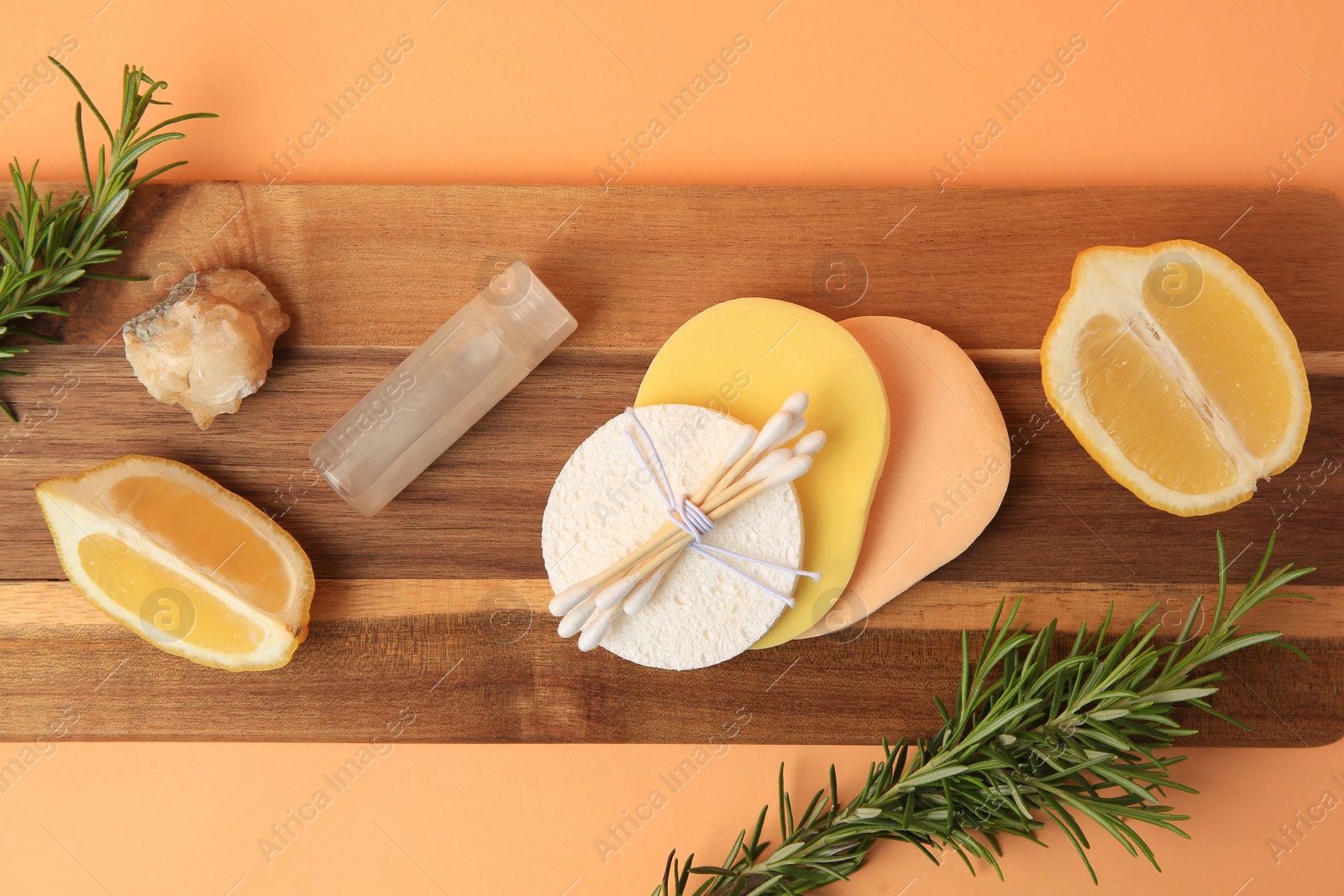 Photo of Lemon face cleanser. Fresh citrus fruits, rosemary and personal care products on pale orange background, top view