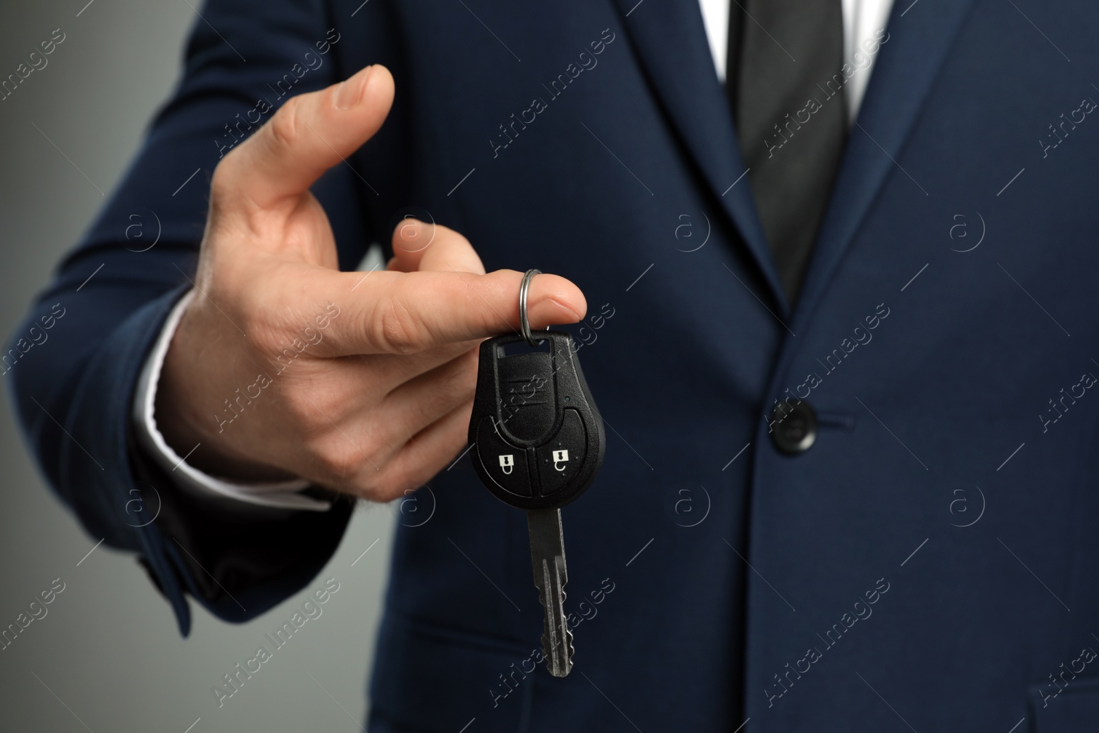 Photo of Young man holding new car key, closeup