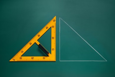 Photo of Ruler and triangle drawn with chalk on green board, top view