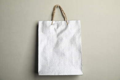 Photo of Silver shopping paper bag on grey background