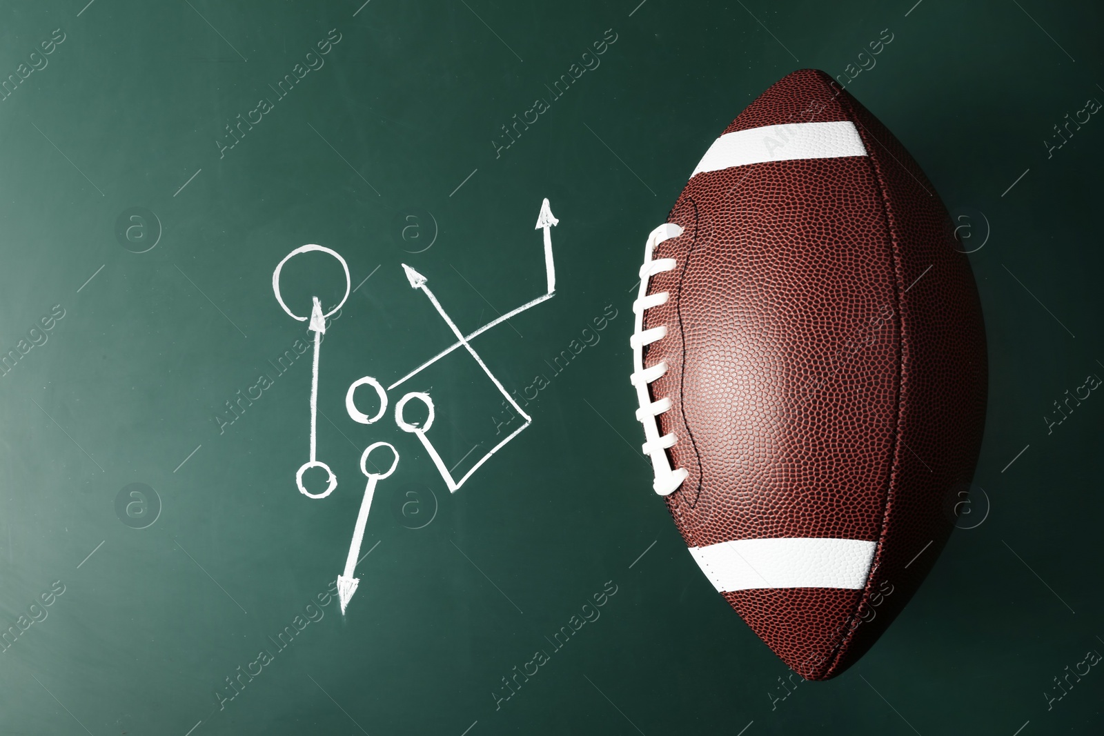 Photo of Chalkboard with football game scheme and rugby ball, top view