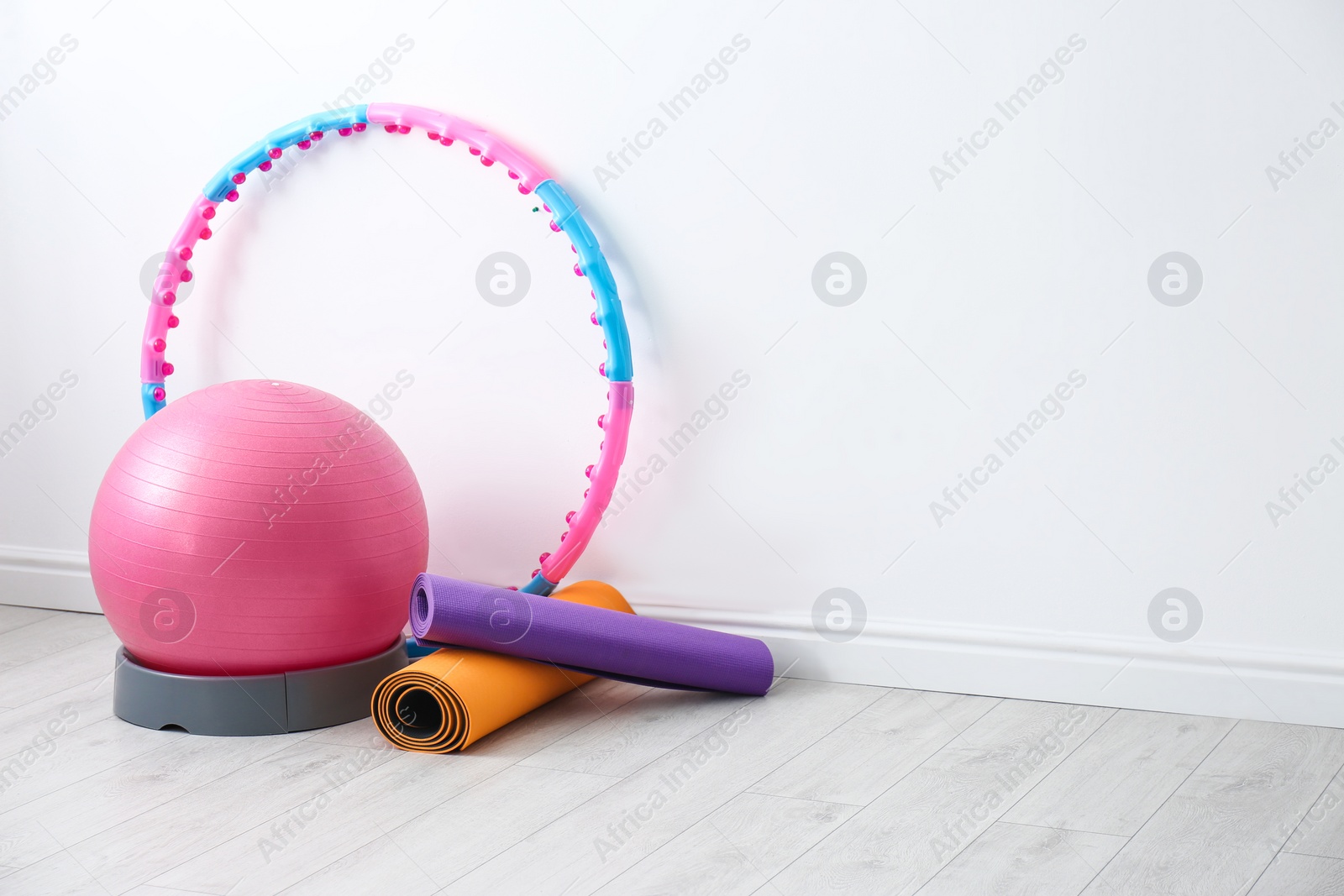 Photo of Different sports equipment near white wall in gym. Space for text