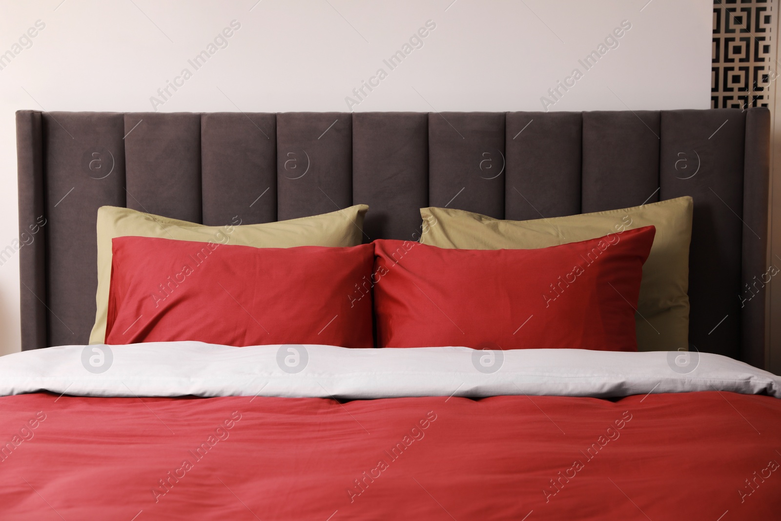 Photo of Comfortable bed with cushions in room. Interior design