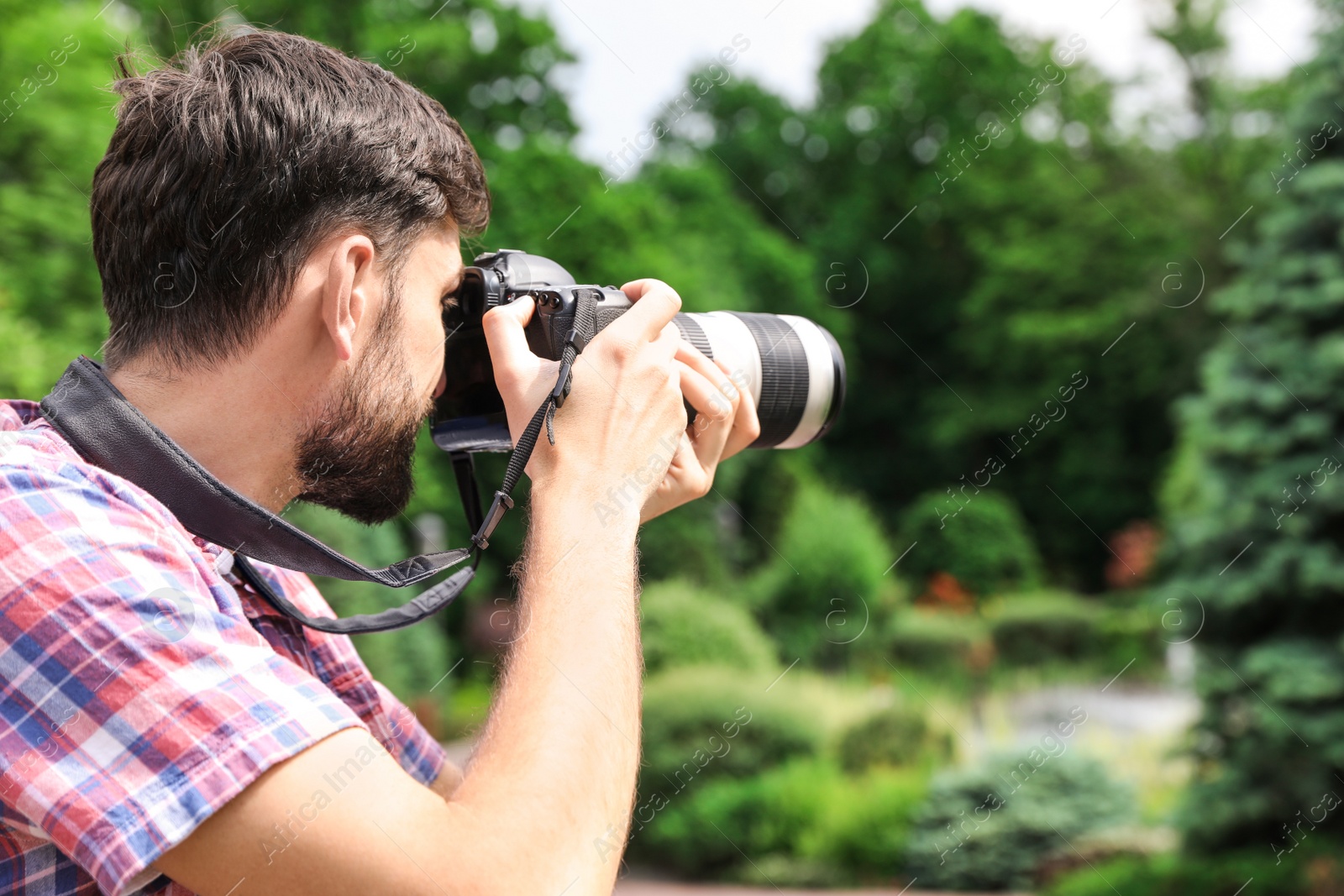 Photo of Photographer taking photo with professional camera in park