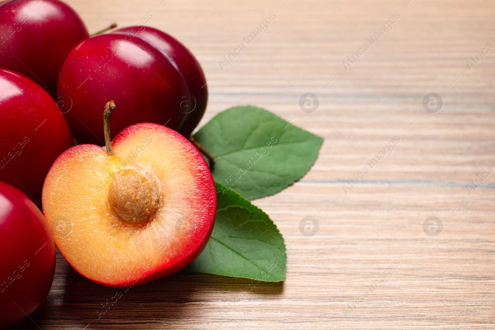 Photo of Fresh ripe cherry plums on wooden table, closeup