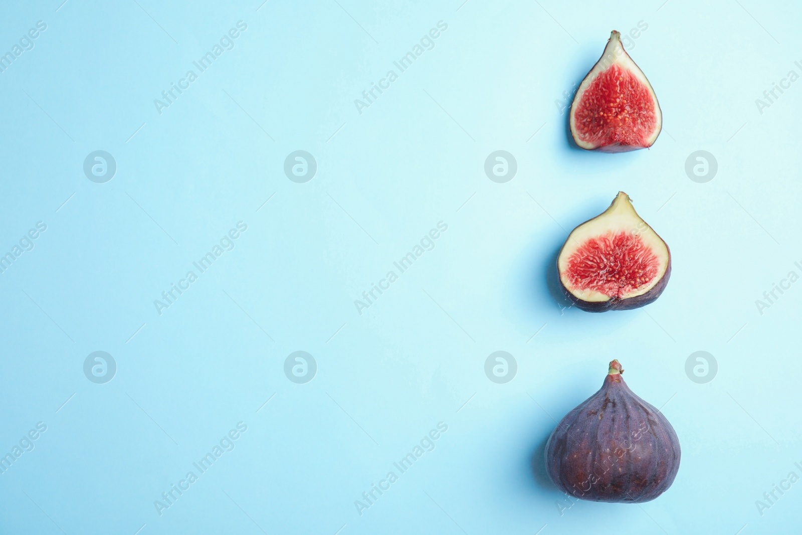 Photo of Delicious ripe figs on light blue background, flat lay. Space for text