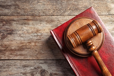 Judge's gavel and book on wooden background, top view. Law concept