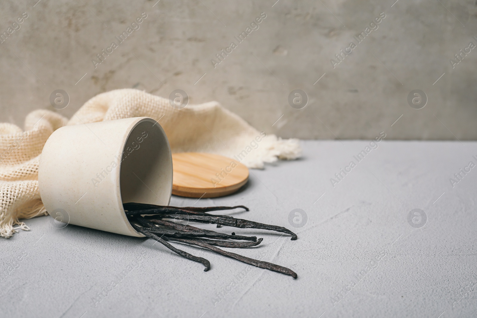 Photo of Cup with vanilla sticks on table