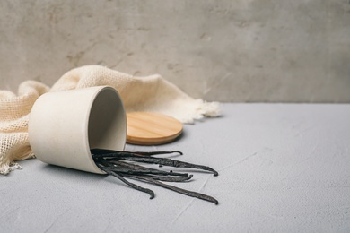 Photo of Cup with vanilla sticks on table