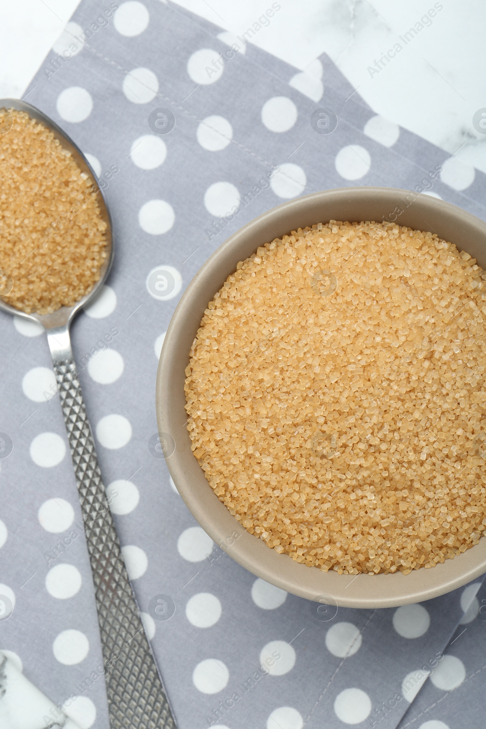 Photo of Brown sugar in bowl and spoon on table, top view