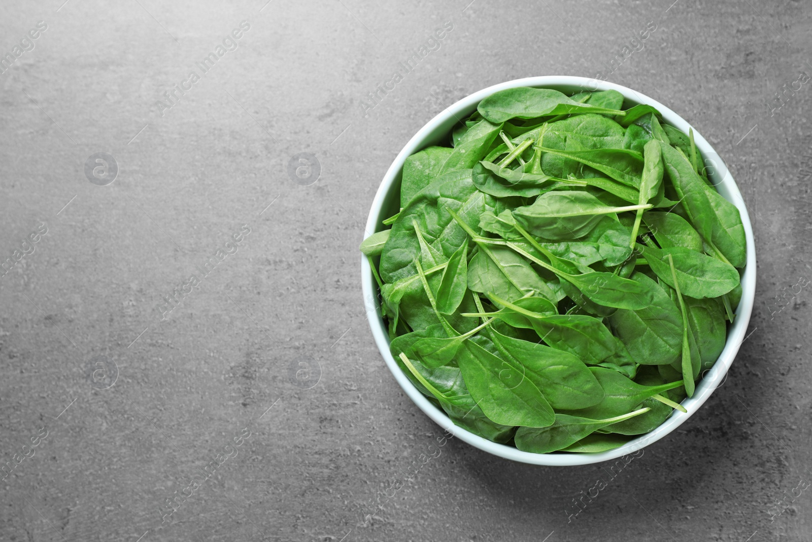 Photo of Fresh green healthy spinach on grey table, top view. Space for text