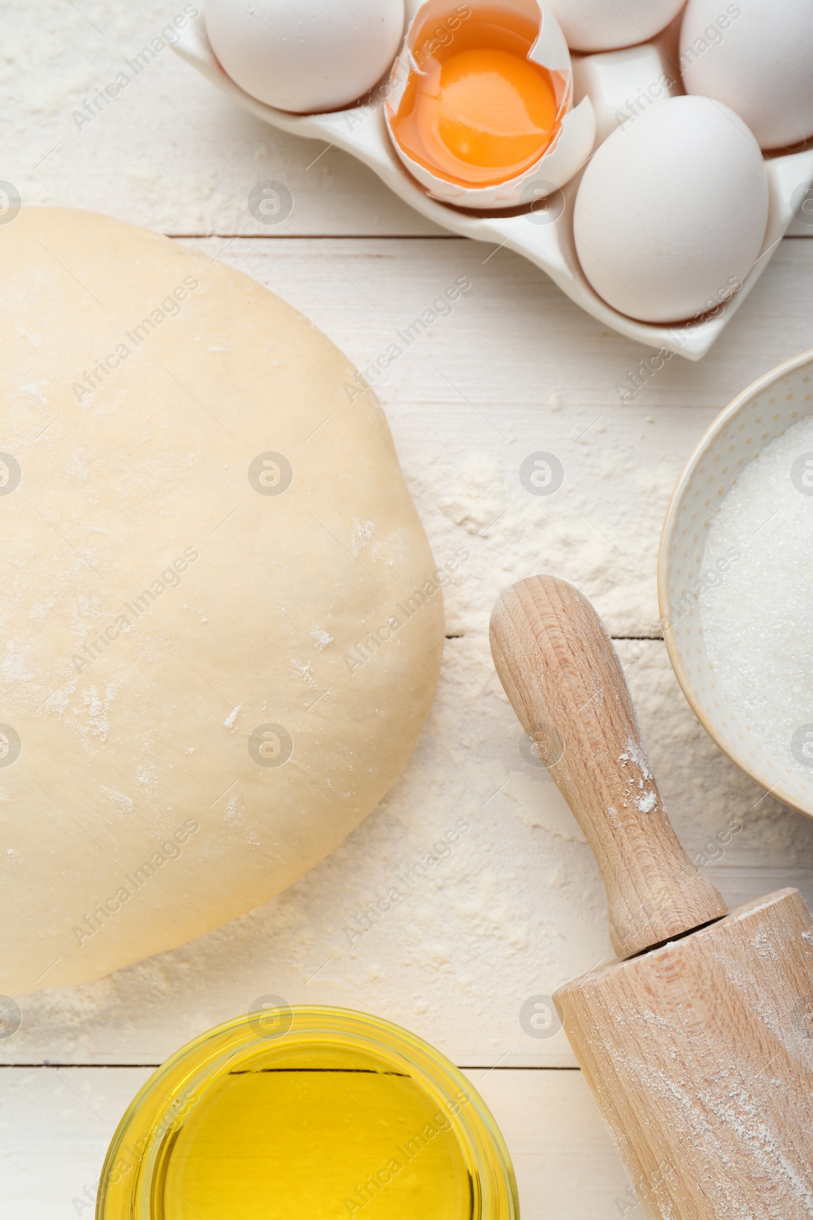 Photo of Fresh yeast dough and ingredients on white wooden table, flat lay