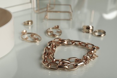 Photo of Stylish golden necklace on table, closeup. elegant bijouterie