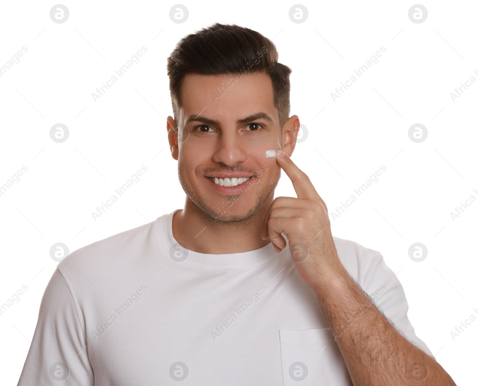 Photo of Handsome man applying face cream on white background