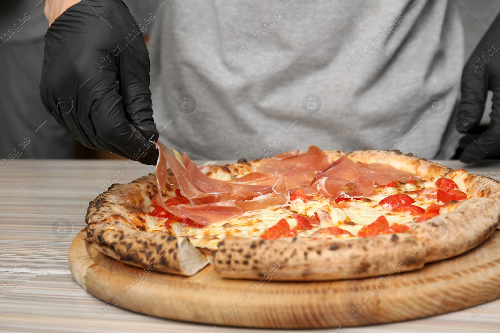 Photo of Professional chef preparing Italian oven baked pizza in restaurant, closeup