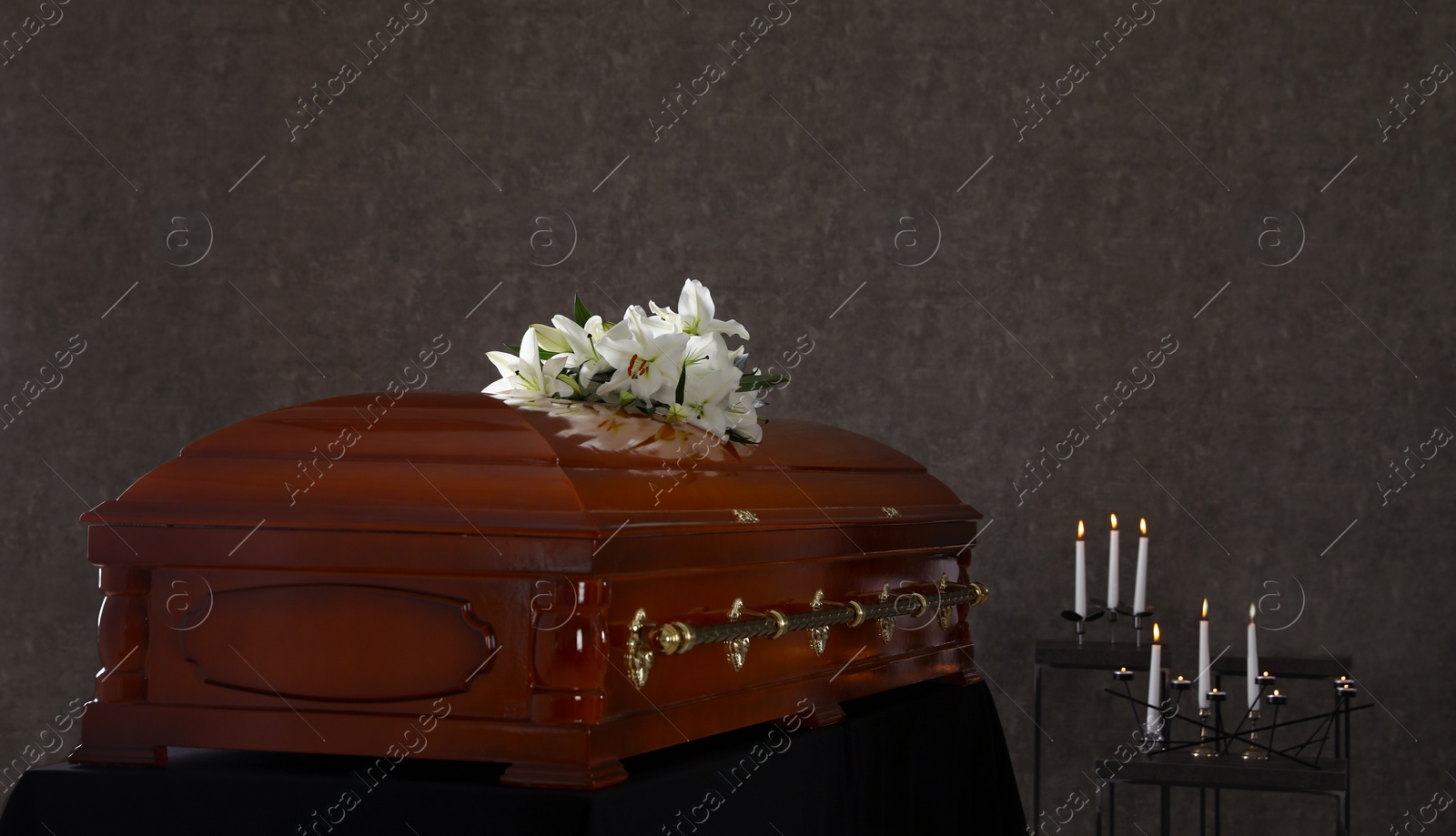 Photo of Wooden casket with white lilies in funeral home