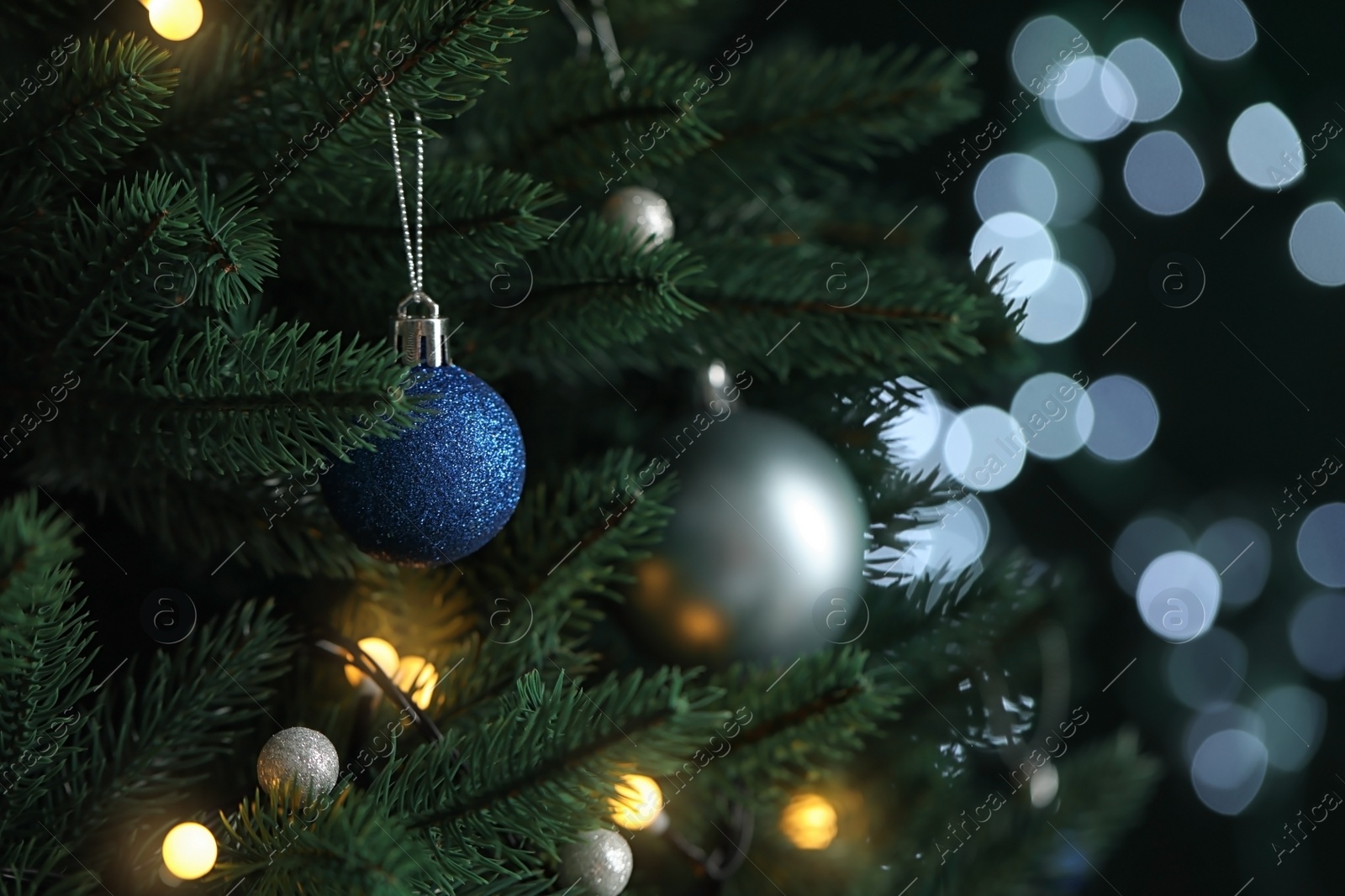 Photo of Beautiful Christmas tree with decor against blurred lights on background