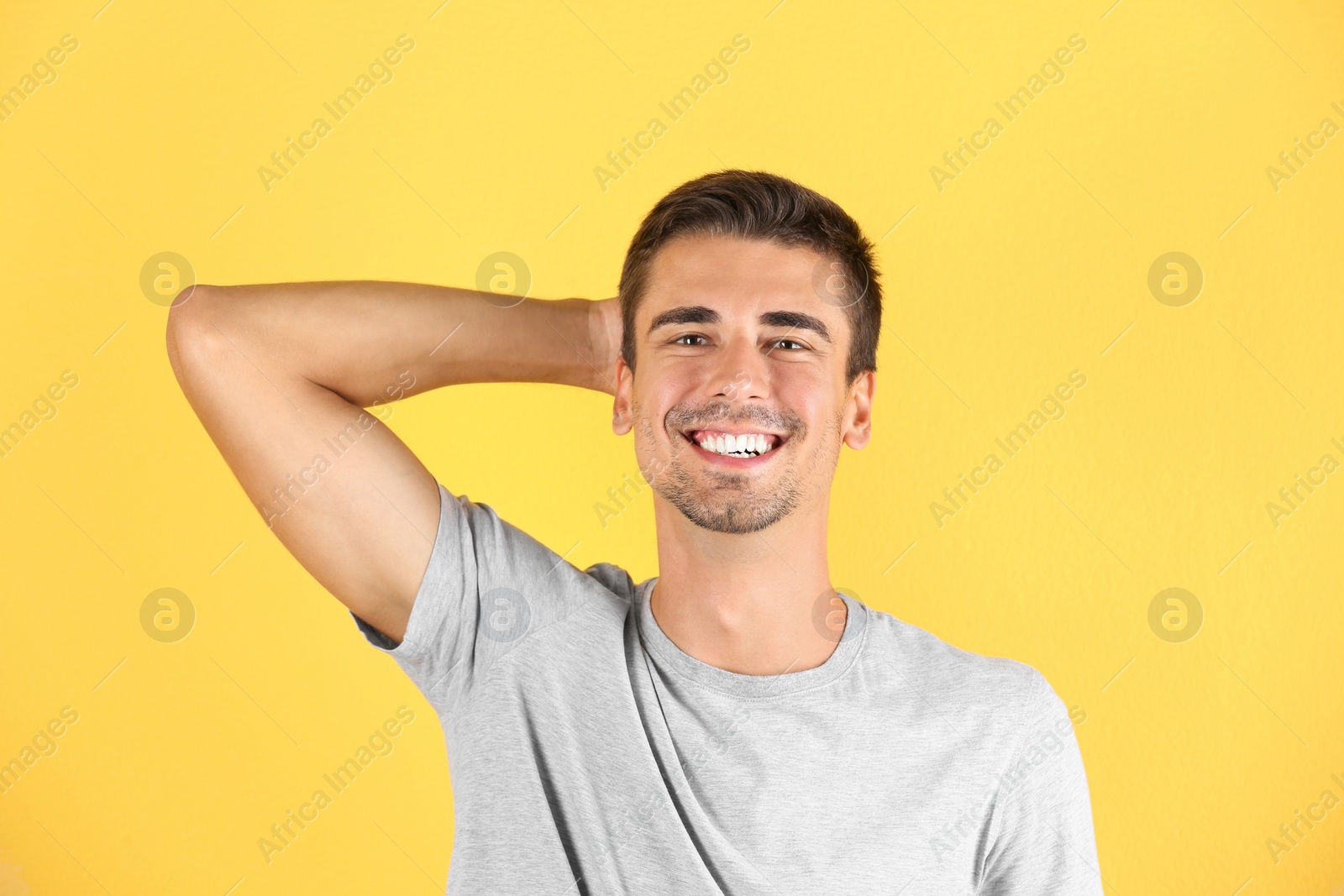 Photo of Portrait of handsome young man smiling on color background