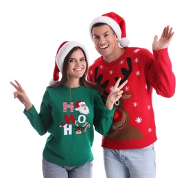 Photo of Beautiful happy couple in Santa hats and Christmas sweaters on white background