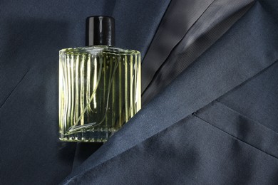 Luxury men's perfume in bottle on grey jacket, top view. Space for text