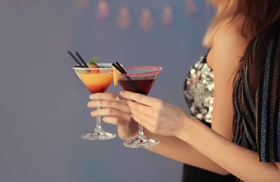 Photo of Young women with martini cocktails on grey background, closeup. Space for text