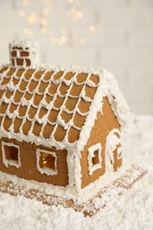 Photo of Beautiful gingerbread house decorated with icing on snow