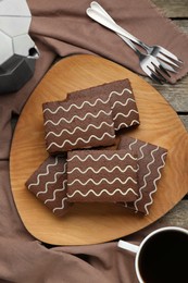 Photo of Tasty chocolate sponge cakes and hot drink on wooden table, flat lay