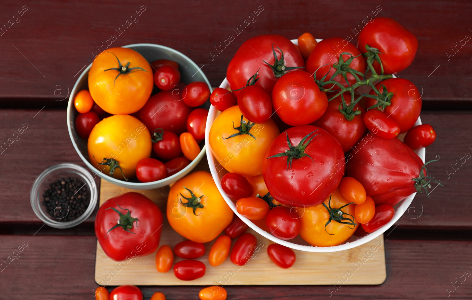 Photo of Bowls with fresh tomatoes and spices on wooden table, flat lay