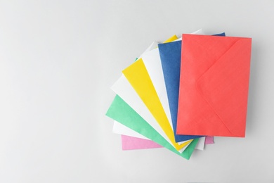 Colorful paper envelopes on light background, top view. Space for text