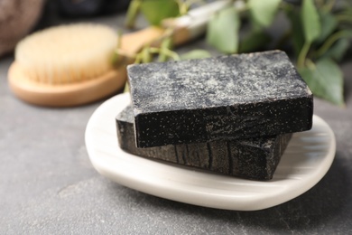 Photo of Natural tar soap on grey stone table, closeup