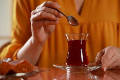 Photo of Woman with traditional Turkish tea at table, closeup