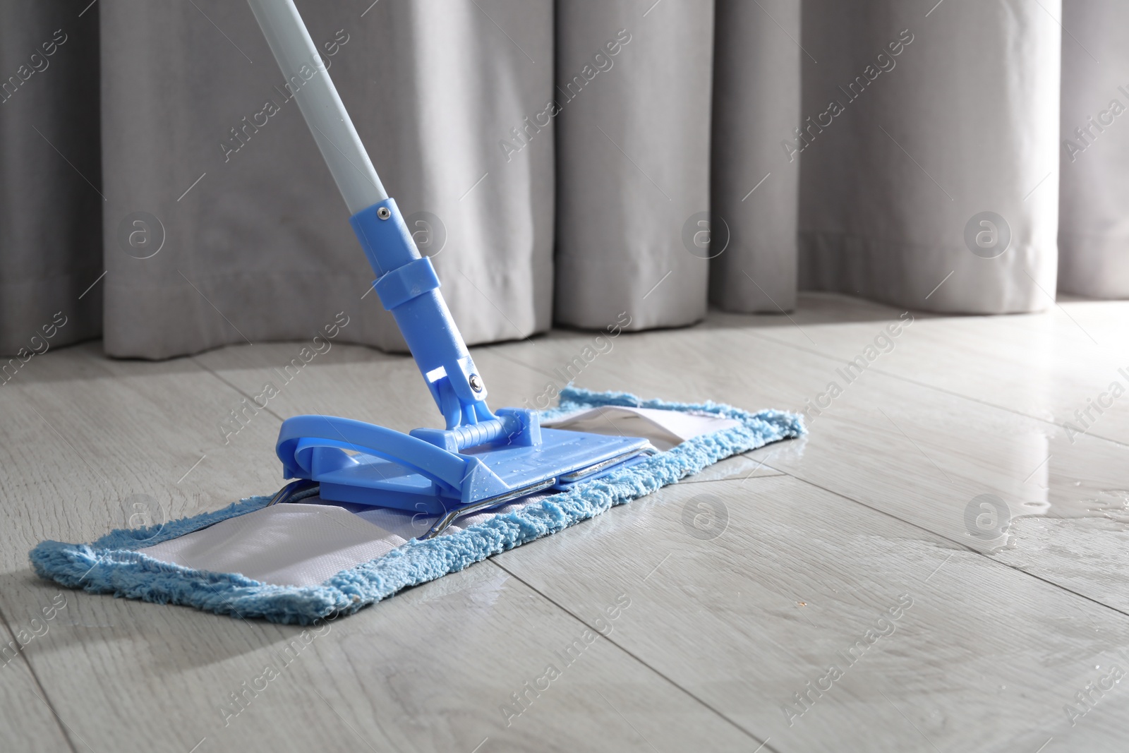 Photo of Cleaning white parquet floor with mop, closeup. Space for text