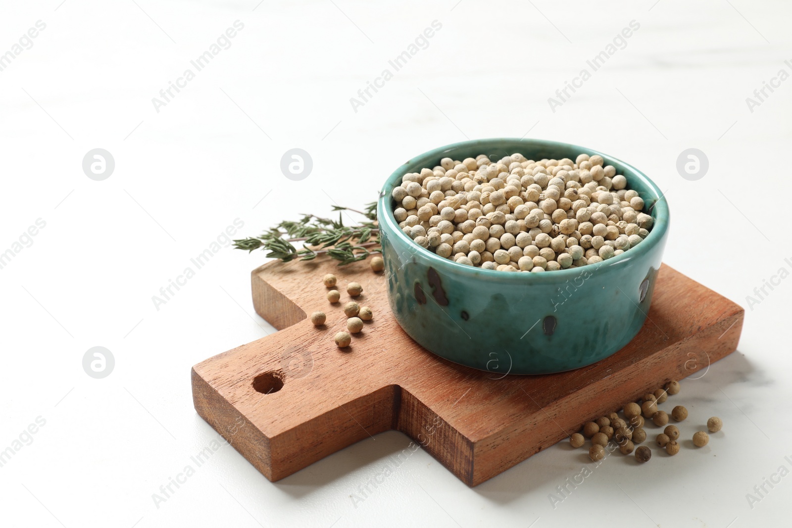 Photo of Aromatic spice. White pepper in bowl on white marble table, space for text