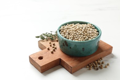 Photo of Aromatic spice. White pepper in bowl on white marble table, space for text