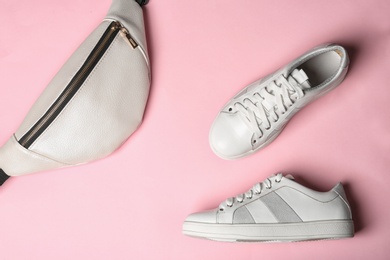 Flat lay composition of stylish shoes and bum bag on color background