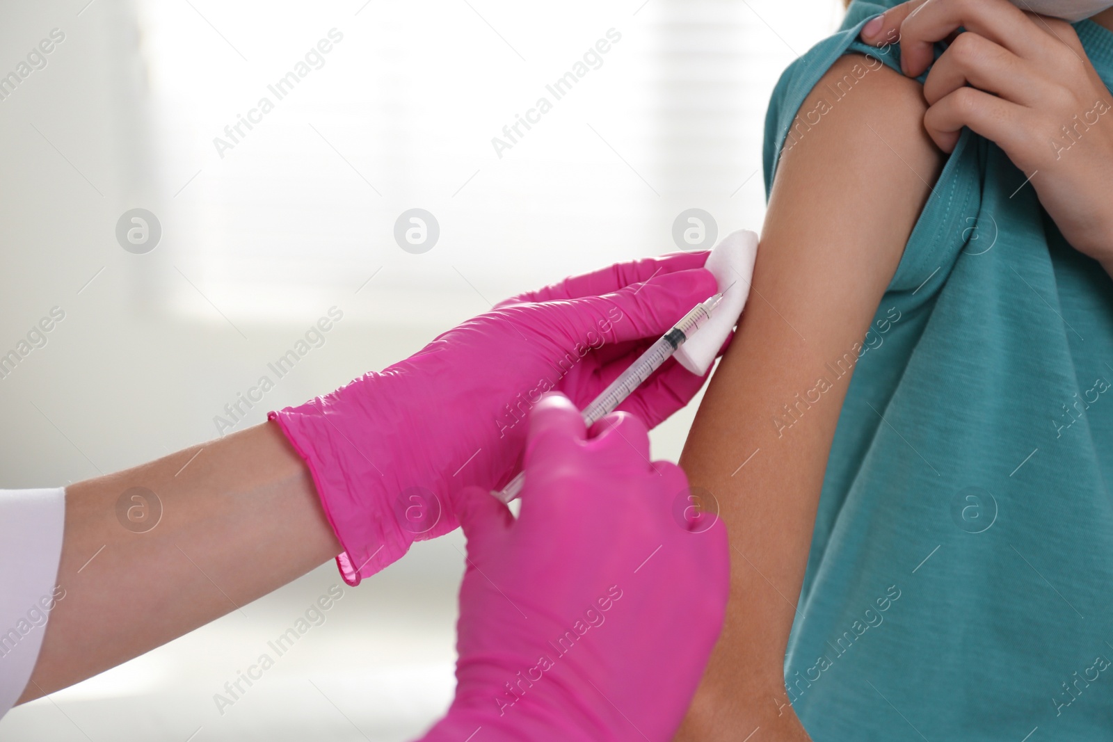 Photo of Doctor vaccinating little girl in hospital, closeup. Health care