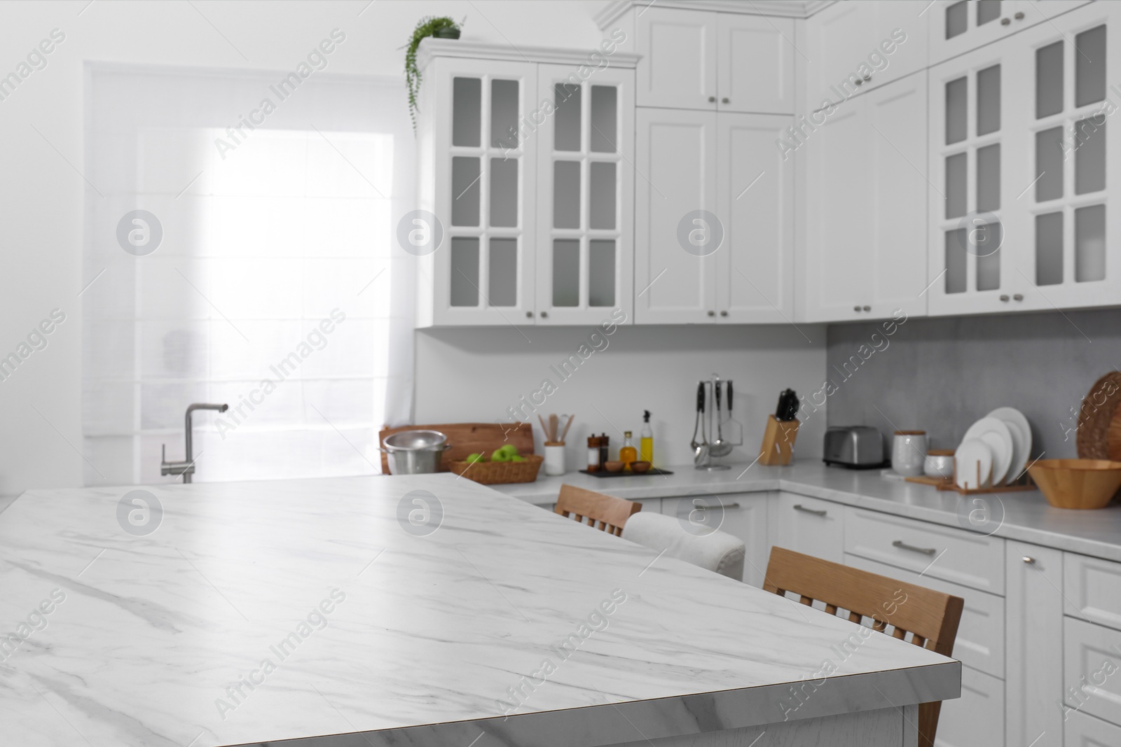 Photo of Stylish white marble table in kitchen. Interior design