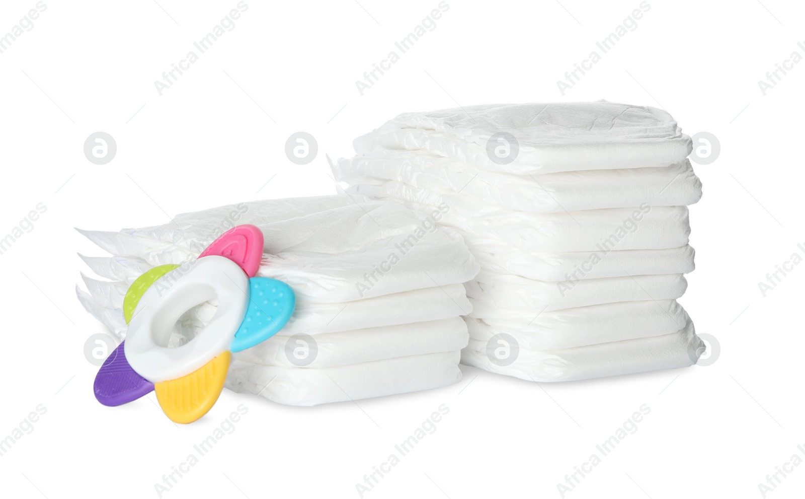 Photo of Disposable diapers and teether on white background