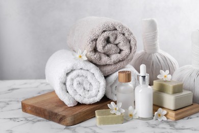 Photo of Composition with spa supplies and flowers on white marble table